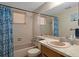 Classic bathroom features tile walls, shower-tub combo, and a large mirror above the sink at 6930 El Camino Paloma St, Port Richey, FL 34668