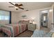 Bedroom with ceiling fan, neutral walls, and doorway to the en suite bathroom at 6930 El Camino Paloma St, Port Richey, FL 34668