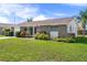 Inviting home exterior featuring a stone facade, green lawn, and an American flag at 6930 El Camino Paloma St, Port Richey, FL 34668
