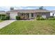 Charming single-story home with a lush green lawn and beautiful stone accents at 6930 El Camino Paloma St, Port Richey, FL 34668