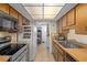 Efficient kitchen with wood cabinets, tile floors, and ample counter space at 6930 El Camino Paloma St, Port Richey, FL 34668