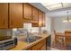 Kitchen area with wood cabinets and countertops, with a view into the dining room at 6930 El Camino Paloma St, Port Richey, FL 34668