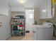 Laundry room with washer and dryer, storage shelving, and adjacent utility area at 6930 El Camino Paloma St, Port Richey, FL 34668