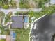 Aerial view of a backyard with a pool, lush greenery, dock, and boat lift on a waterfront property at 6936 River Rd, New Port Richey, FL 34652