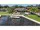 Aerial view showcasing waterfront home, pool, and private dock on the lake at 6936 River Rd, New Port Richey, FL 34652