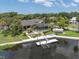 An aerial view of the backyard with a pool, dock, and boat lift on a waterfront property at 6936 River Rd, New Port Richey, FL 34652