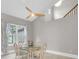 Dining area featuring a glass table, designer ceiling fan and large picture window at 6936 River Rd, New Port Richey, FL 34652