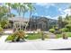 Gorgeous home with a screened lanai, lush landscaping, and a brick walkway leading to the entrance at 6936 River Rd, New Port Richey, FL 34652