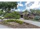 Beautiful single-story home with brick facade, lush landscaping, and a curved driveway at 6936 River Rd, New Port Richey, FL 34652