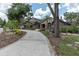 Charming front exterior with a curved driveway and beautiful landscaping at 6936 River Rd, New Port Richey, FL 34652
