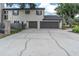 Two-car garage with a wide driveway in front of a two-story home at 6936 River Rd, New Port Richey, FL 34652