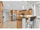 Open kitchen with wood cabinets, stainless steel appliances, granite counters, and eat-in breakfast bar at 6936 River Rd, New Port Richey, FL 34652