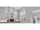 Bright living room featuring a brick fireplace, tall windows, and an open layout at 6936 River Rd, New Port Richey, FL 34652