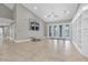 Open living room with large windows, high ceilings, tile floors, and custom built-in shelving at 6936 River Rd, New Port Richey, FL 34652