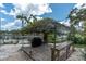 Outdoor kitchen with a bar, brick patio, and grill, all under a charming vine-covered pergola at 6936 River Rd, New Port Richey, FL 34652