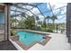 Sparkling pool surrounded by brick pavers with a view of the lake at 6936 River Rd, New Port Richey, FL 34652