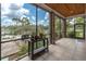 Relaxing screened porch with brick columns and tranquil lake views beyond the enclosure at 6936 River Rd, New Port Richey, FL 34652