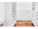 A spacious walk-in closet with custom shelving, drawers, and hardwood floors offers ample storage at 6936 River Rd, New Port Richey, FL 34652