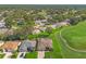 Aerial view of beautiful homes next to a golf course fairway featuring lush trees and landscaping in a residential community at 7328 Blue Skies Dr, Spring Hill, FL 34606