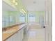 Spacious bathroom with double vanity, tub, and two glass door showers, and decorative glass block windows at 7328 Blue Skies Dr, Spring Hill, FL 34606