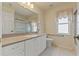 This bathroom features white cabinetry, a large mirror, and a shower with sliding glass doors at 7328 Blue Skies Dr, Spring Hill, FL 34606