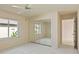 This bedroom boasts carpet, a mirrored closet, a ceiling fan, and a large window overlooking the landscaping at 7328 Blue Skies Dr, Spring Hill, FL 34606