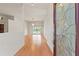 Bright foyer with hardwood floors leads to the living area, with views of the pool through sliding glass doors at 7328 Blue Skies Dr, Spring Hill, FL 34606