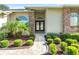 Inviting front entrance with double doors, brick pathway, and manicured shrubs offers curb appeal at 7328 Blue Skies Dr, Spring Hill, FL 34606