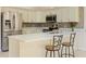 Modern kitchen features stainless appliances, counter seating, and mosaic backsplash at 7328 Blue Skies Dr, Spring Hill, FL 34606