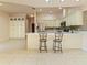 Open kitchen with white cabinetry, an island with seating, and tile floors at 7328 Blue Skies Dr, Spring Hill, FL 34606
