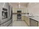 Modern kitchen with stainless steel appliances, white cabinets, and tile backsplash at 7328 Blue Skies Dr, Spring Hill, FL 34606