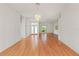 Spacious living room features hardwood floors, a chandelier, and large windows, offering ample natural light at 7328 Blue Skies Dr, Spring Hill, FL 34606