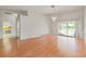 Spacious living room boasts wood floors, chandelier, and access to other rooms at 7328 Blue Skies Dr, Spring Hill, FL 34606