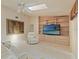 Comfortable living room with tile floors, built-in shelving, a ceiling fan, and bright natural light at 7328 Blue Skies Dr, Spring Hill, FL 34606