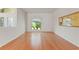 Bright living room featuring hardwood floors and a large window with decorative valance at 7328 Blue Skies Dr, Spring Hill, FL 34606