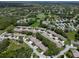 Expansive aerial shot of a residential community with lush greenery, winding streets, and a tranquil pond at 7445 Nature Walk Dr, Spring Hill, FL 34606