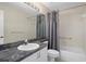 Bathroom with a granite countertop, white cabinets, a shower with gray curtain, and updated fixtures at 7445 Nature Walk Dr, Spring Hill, FL 34606