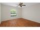 Bright bedroom featuring wood floors, ceiling fan, and a window with natural light at 7445 Nature Walk Dr, Spring Hill, FL 34606