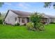 Charming exterior view of home with manicured lawn, lush landscaping, and an enclosed lanai at 7445 Nature Walk Dr, Spring Hill, FL 34606