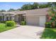 Single-story house boasting a clean driveway, verdant landscaping, and a well-kept lawn and garden at 7445 Nature Walk Dr, Spring Hill, FL 34606