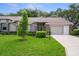 Charming single-story home featuring a well-maintained lawn, mature trees, and a cozy, inviting facade at 7445 Nature Walk Dr, Spring Hill, FL 34606