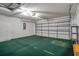 Spacious garage featuring an automatic door, storage cabinets, and green carpet at 7445 Nature Walk Dr, Spring Hill, FL 34606