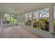 Enclosed lanai with tile flooring and expansive windows offering scenic backyard views at 7445 Nature Walk Dr, Spring Hill, FL 34606