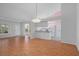 Bright living room with a view of the kitchen, with hardwood floors, chandelier, and a view to the lanai at 7445 Nature Walk Dr, Spring Hill, FL 34606