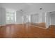 Bright living room featuring hardwood floors, ceiling fan, and mirrored wall with a double door entryway at 7445 Nature Walk Dr, Spring Hill, FL 34606