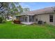 A covered, screened-in lanai offers a relaxing spot overlooking the beautiful green backyard and lush plantings at 7445 Nature Walk Dr, Spring Hill, FL 34606