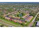 Aerial view of a well-maintained community with lush landscaping and a central pond at 7715 Radcliffe Cir, Port Richey, FL 34668