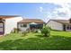 A well-maintained backyard featuring a patio with an umbrella and lush green lawn at 7715 Radcliffe Cir, Port Richey, FL 34668