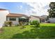 A well-maintained backyard featuring a patio with an umbrella and lush green lawn at 7715 Radcliffe Cir, Port Richey, FL 34668