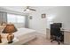 Bright bedroom with ceiling fan, window, and a quaint desk with a comfortable chair at 7715 Radcliffe Cir, Port Richey, FL 34668